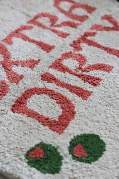 a white rug with red and green lettering on it that says happy holidays written in large letters