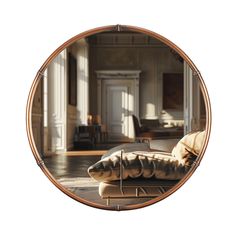 an oval mirror reflecting a living room with furniture