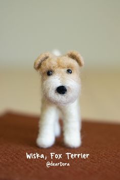 a small white and brown dog toy sitting on top of a table