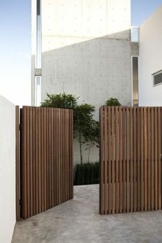 two wooden gates in front of a white building