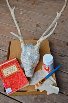 a deer's head is sitting on top of a cardboard box with other items