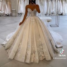 a woman taking a selfie in her wedding dress at the bridal gown shop