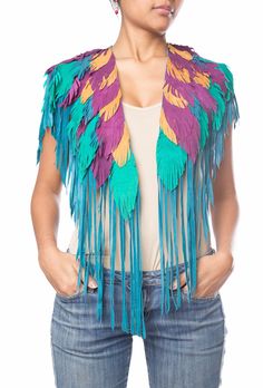 a woman with her hands on her hips wearing a colorful feathered jacket and jeans