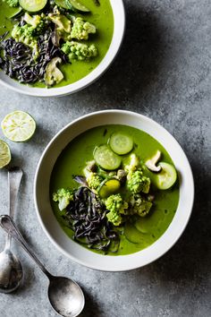 two bowls filled with green soup and vegetables