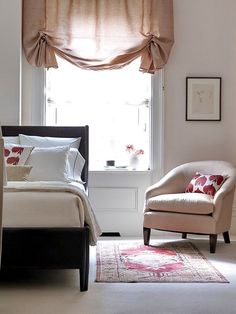 a bed room with a neatly made bed and two chairs next to a large window