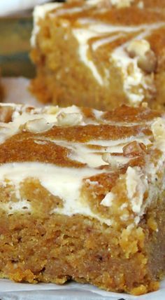 two pieces of carrot cake sitting on top of a white paper towel next to each other