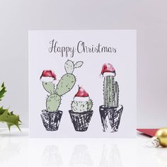 a christmas card with three cacti in pots