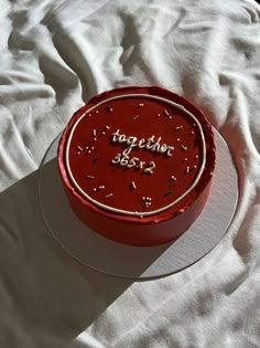 a red birthday cake sitting on top of a white table