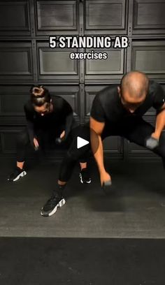 two men in black shirts are doing squats with their hands on the ground and one man