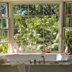 a bath tub sitting next to two windows