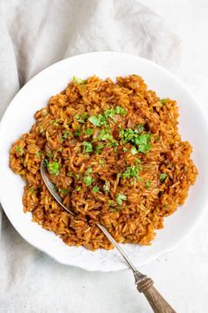 a white bowl filled with mexican rice and topped with cilantro