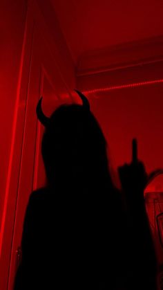 a woman with horns in the dark pointing at something