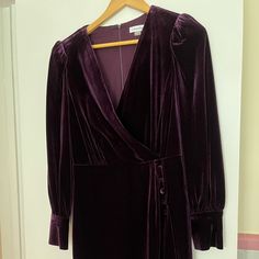 Nwot Aubergine Colored Dress Approx. 37" Long From Center Back Neck To Hem. Length Is Based On Size 6 And Varies 1/4" Between Sizes Tailored Fit Through The Chest, Waist, And Hips; Sits Close To The Body Velvet Fabric: Smooth And Soft; Stretchy And Supportive Surplice V-Neck; Sheath Silhouette Hidden Zipper At Center Back Shirred-Shoulder Long Sleeves Covered Buttons At Side Front Of Overlapping Skirt And At Cuffs Lined Polyester/Spandex; Lining: Polyester Dry Clean Formal Purple Dress With Buttons, Elegant Purple Dress With Button Closure, Aubergine Color, Velvet Dresses, Surplice Dress, Nike Tennis Dress, Trim Dress, Large Sweaters, Velvet Trim