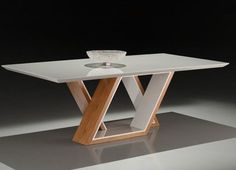 a glass table with wooden legs and a bowl on the top, in front of a black background