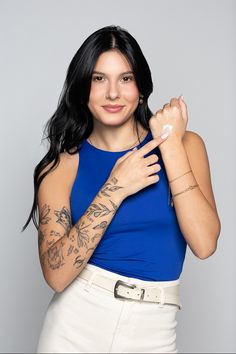 a woman with tattoos on her arms and arm is holding something in her right hand