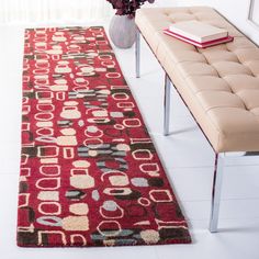 a large red rug in the middle of a living room with a bench and window