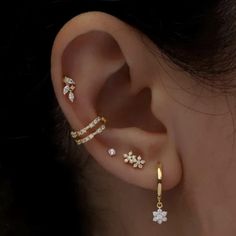 a woman's ear with three different types of piercings