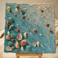 an easel with seashells painted on it