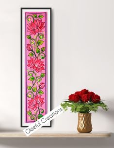 there is a vase with flowers on the shelf next to a wall hanging art piece