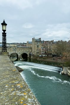 a river running through a city next to a street light with buildings in the background