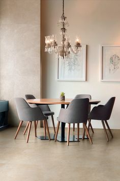 a dining table with four chairs and a chandelier hanging from the ceiling above it