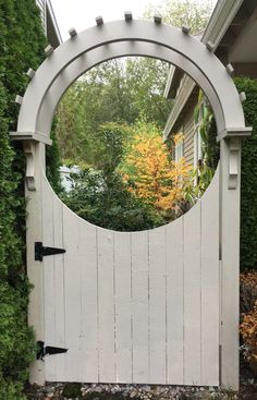 a white gate with a circular mirror on it