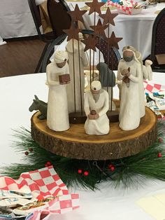 a group of figurines sitting on top of a tree stump in front of a table