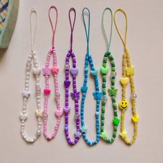 five necklaces are lined up on a table with the same bead pattern and colors