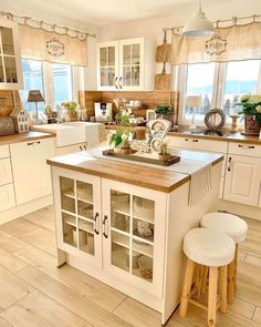 a kitchen filled with lots of white cabinets and counter top next to a wooden floor