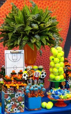 a table topped with lots of tennis balls next to a potted plant