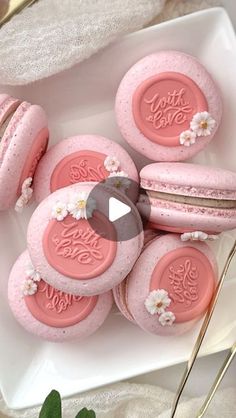 pink macaroons are sitting on a white plate with flowers and the words love you