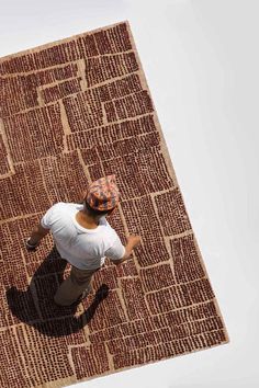 a man standing on top of a brown rug