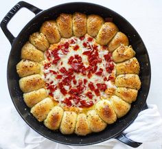 a pan filled with bread and cheese covered in sauce