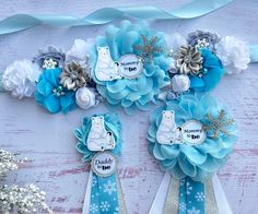 some blue and silver hair clips with snowflakes on them next to white flowers