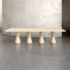 three white pedestals stand in front of a concrete wall, with the top off to the side