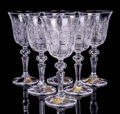 five crystal goblets are lined up in a row