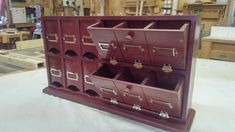 a wooden display case filled with lots of drawers on top of a white tablecloth