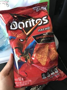 someone is holding up a bag of doritos