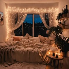 a bedroom with lights strung from the ceiling and bed in front of a large window