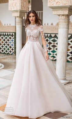 a woman in a white wedding dress standing on a tile floor with columns behind her