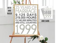 an easel with a sign that reads 25 years of marriage and two flowers on it