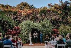 a bride and groom standing at the end of their wedding ceremony in front of an archway