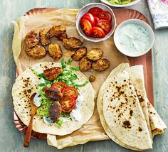 there are two pita breads on the tray with different toppings and vegetables