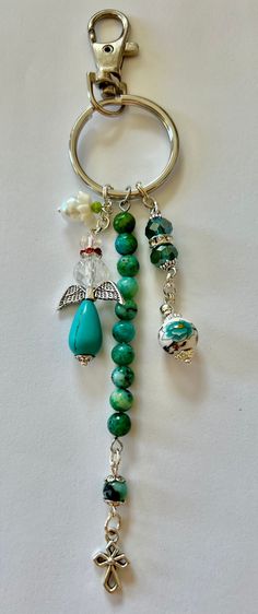 a keychain with charms and beads hanging from it's side on a white surface