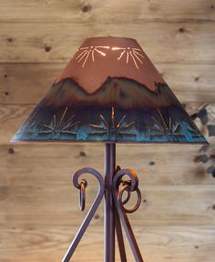 a lamp that is sitting on top of a wooden table next to a wood wall