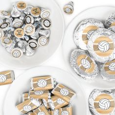 three white plates filled with silver and gold volleyball candy