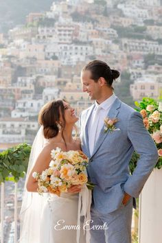 a bride and groom standing together in front of the city