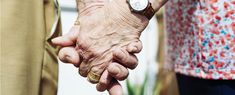 an older person holding the hand of a younger person