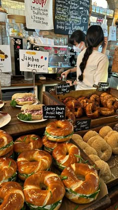 sandwiches and bagels are on display in a bakery