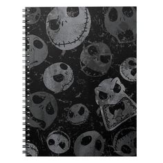 a spiral notebook with skulls and faces on the front, one is black and white